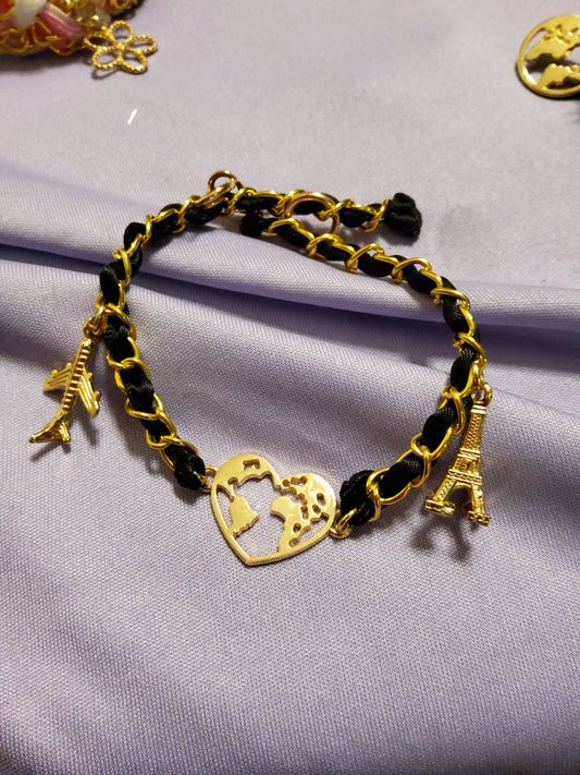 Midnight in Paris is chic, bold, and beautifully refined. A sleek black ribbon braid weaves through a gold chain, creating a classic contrast that feels both modern and timeless. Finished with a gold Eiffel Tower charm and a heart-shaped world pendant, this bracelet is perfect for dreamers, travelers, and romantics.

SEO Title:

Black & Gold Paris Bracelet • Eiffel Tower Charm Jewelry • Elegant Braided Chain Bracelet • Travel Lover Gift • Parisian Aesthetic